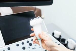 donna medico mano tenendo un' medico gel per ultrasonico sensore di ultrasuono macchina nel il clinica foto