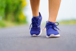 piedi di donna che corrono su strada, allenamento fitness sano della donna