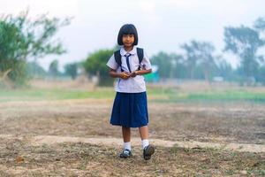 studente asiatico in uniforme che studia nella campagna della thailandia foto