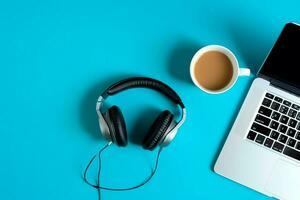 musica o Podcast sfondo con elettronico dispositivi, cuffia, caffè e il computer portatile su ufficio scrivania concetto di ai generato foto