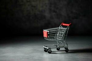 composizione di nero Venerdì shopping carrello con regalo scatole o borse su buio sfondo e copia spazio concetto di ai generato foto