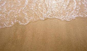 bolla bianca dell'onda del mare sulla spiaggia foto