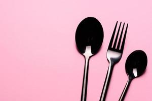 cucchiaio e forchetta di metallo isolati su sfondo rosa