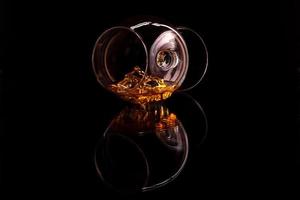 whisky con ghiaccio in vetro isolato su sfondo nero foto