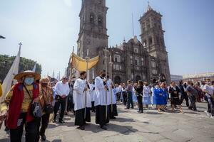 puebla, Messico 2023 - preti e membri di il cattolico Chiesa trasportare su un' processione nel davanti di il Cattedrale di puebla. culto di cattolico cristiano simboli foto