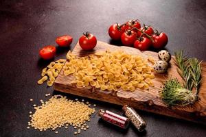 ingredienti per cucinare la pasta su uno sfondo scuro foto