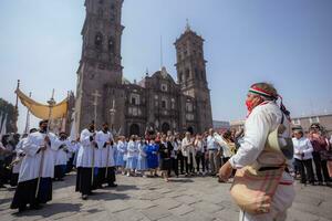 puebla, Messico 2023 - preti e membri di il cattolico Chiesa trasportare su un' processione nel davanti di il Cattedrale di puebla. culto di cattolico cristiano simboli foto