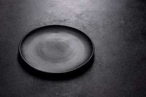 piatto nero vuoto su sfondo di pietra scura con spazio libero foto