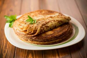 lotto di Pancakes magro Pancakes nel un' piatto, su di legno tavolo. foto