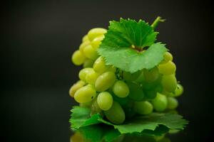 un' mazzo di maturo verde uva con le foglie. foto