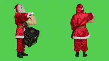 padre Natale consegna nel carta Borsa, persona vestito come Santa Claus con bianca barba consegna veloce cibo ordine durante vacanza celebrazione. personaggio con termico zaino, pieno corpo schermo verde. foto