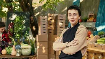 sorridente donna contadino con grembiule vendita azienda agricola cibo a strada mercato all'aperto, preparazione per vendere biologico produrre. positivo persona mostrando naturale homegrown fresco frutta e verdure. foto