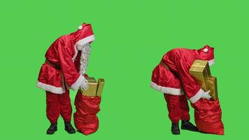 padre Natale trasporta Borsa con regali per natale vigilia vacanza celebrazione, consegna i regali e giocattoli per bambini in giro il mondo. uomo raffigurante Santa e Tenere rosso sacco con pacchi. foto