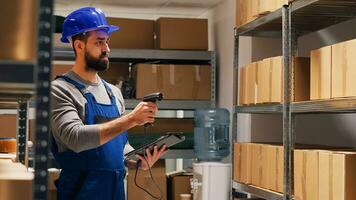 maschio supervisore lettura codici a barre su pacchi nel deposito, puntamento scanner a cartone scatole e controllo scorta. uomo nel tuta da lavoro Tenere tavoletta nel Conservazione camera, industriale merce. foto