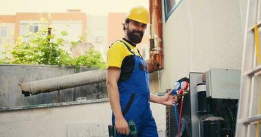 ritratto di esperto meccanico guardare a refrigerante livelli nel aria condizionatore mentre utilizzando collettore indicatori per meticolosamente misurare il pressione nel HVAC sistema, garantendo efficiente raffreddamento prestazione foto