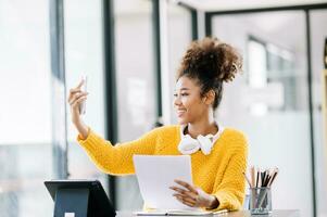 africano femmina Università alunno concentrandosi su sua in linea aula con tavoletta e il computer portatile foto