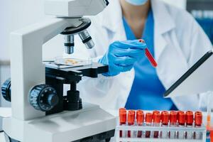 moderno medico ricerca laboratorio. femmina scienziato Lavorando con micro pipette analizzando biochimica campioni, Avanzate scienza chimico laboratorio foto