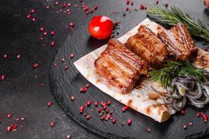 costine fritte con rosmarino, cipolla, salsa su un fondo di cemento foto