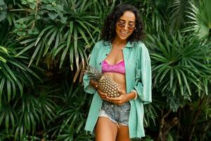 all'aperto estate foto di sorridente bello brunetta donna con ondulato capelli Tenere tropicale frutta.