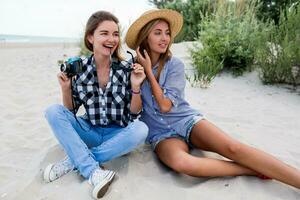 Due donne, sorelle la spesa grande tempo insieme, rilassante vicino oceano, fabbricazione fotografie, ridendo. foto