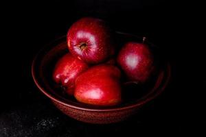 mela rossa succosa fresca con goccioline d'acqua su sfondo scuro foto