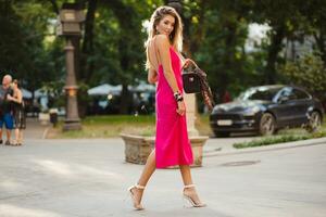 elegante attraente donna indossare rosa sexy estate vestito a piedi nel strada foto