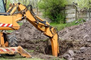 il moderno escavatore esegue lavori di scavo in cantiere
