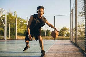 nero uomo fare gli sport, giocando pallacanestro su Alba, attivo stile di vita, soleggiato estate mattina foto