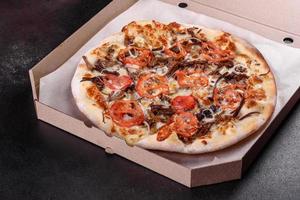pizza calda fresca con carne, funghi, formaggio e pomodori foto