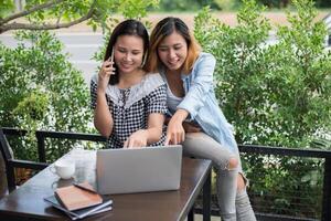 due giovani belle donne che cercano informazioni al computer portatile foto