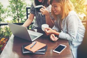 due amici sorridenti che si divertono a lavorare insieme in una caffetteria. foto