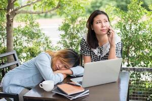 due amici sorridenti che si divertono a lavorare insieme in una caffetteria. foto