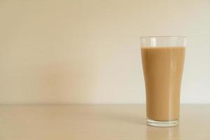 bicchiere di caffè latte con bottiglie di caffè pronte da bere sul tavolo foto