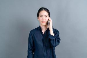 donna asiatica che utilizza il telefono cellulare parlando di affari foto