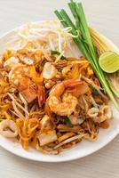 frutti di mare pad thai - tagliatelle saltate in padella con gamberi, calamari o polpo foto