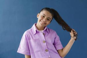 adolescente sorridente e positiva che gioca con i suoi capelli foto