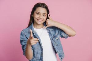 ragazza adolescente mostra un gesto per richiamare, punta un dito foto
