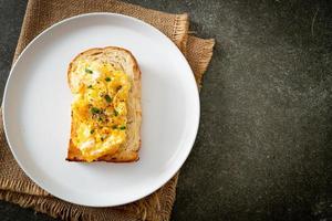 pane tostato con uova strapazzate su piatto bianco foto