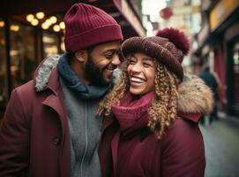 un' coppia Tenere mani mentre ridendo e condivisione un' cappello o Beanie nel inverno città foto