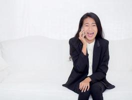 donna asiatica che parla al telefono in soggiorno foto