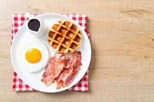 uovo fritto con bacon e waffle per colazione