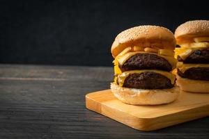 hamburger o hamburger di manzo con formaggio e patatine fritte - stile alimentare malsano foto