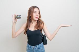 ritratto bella donna asiatica in possesso di carta di credito su sfondo bianco
