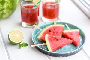 anguria fresca e deliziosa affettata con menta e succo di anguria foto