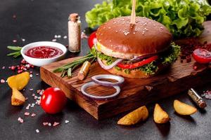 delizioso hamburger fresco fatto in casa su un tavolo di legno foto