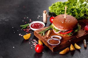 delizioso hamburger fresco fatto in casa su un tavolo di legno foto