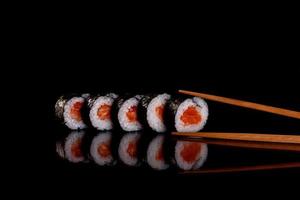 rotoli di sushi freschi e deliziosi su uno sfondo scuro foto