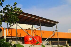 grande arancia acqua serbatoio su il tetto di il Casa foto