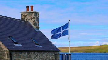 Shetland bandiera agitando su un' tipico medievale Casa nel lerwick centro e porta nel Scozia, Inghilterra foto