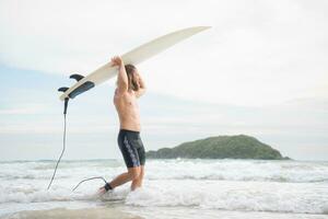 surfer uomo con il suo tavola da surf su il spiaggia. foto